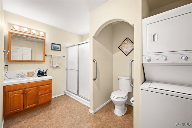 4393 S Colorado Rd, Fort Mohave, AZ 86426 - full bathroom with vanity, toilet, baseboards, a shower stall, and stacked washer / drying machine