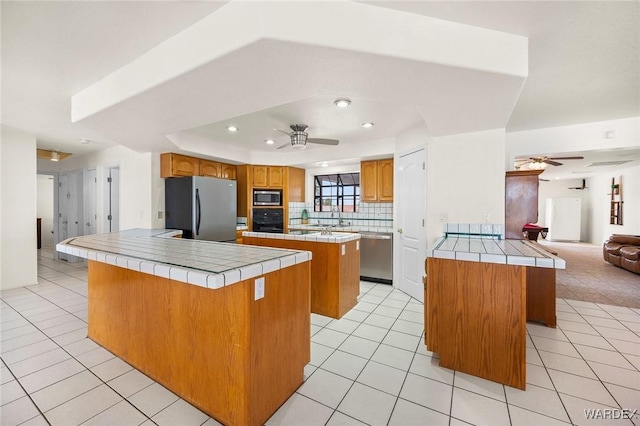 4393 S Colorado Rd, Fort Mohave, AZ 86426 - kitchen with a center island, ceiling fan, tile counters, and stainless steel appliances