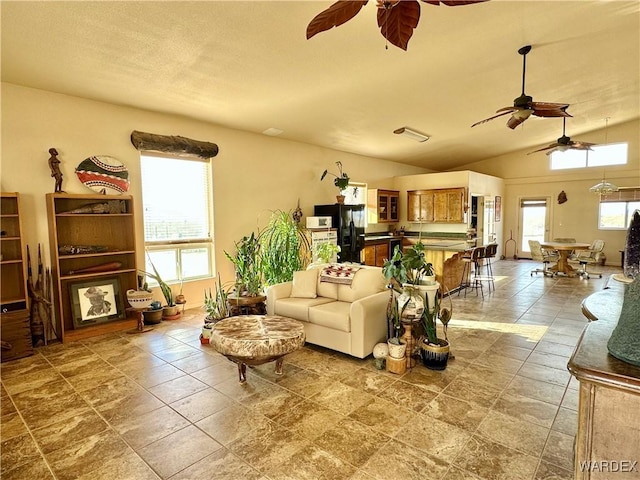 living room with vaulted ceiling and a ceiling fan