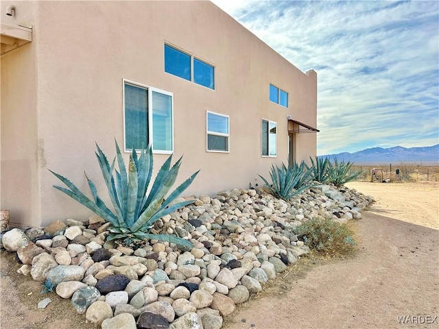 view of side of property featuring a mountain view and stucco siding