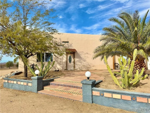 view of front of home with fence and stucco siding