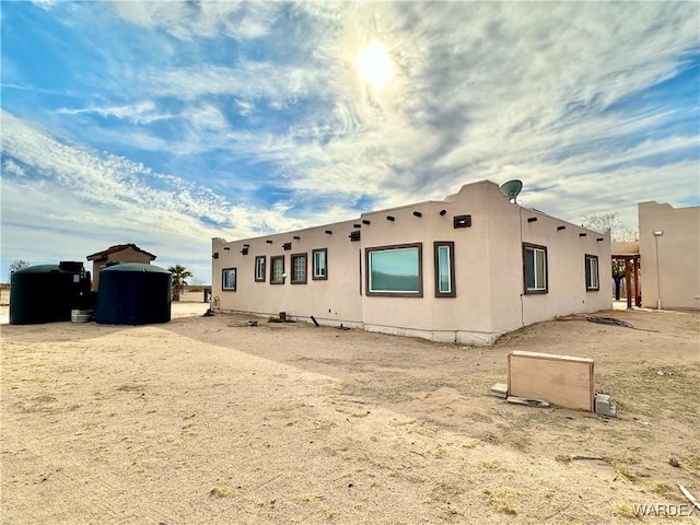 back of property featuring stucco siding