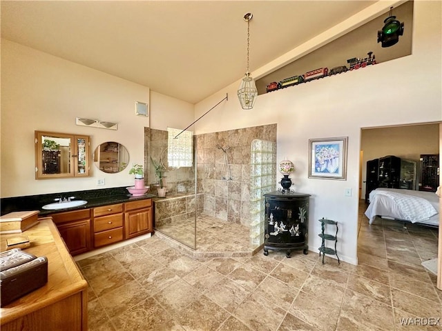 bathroom featuring high vaulted ceiling, connected bathroom, vanity, and walk in shower