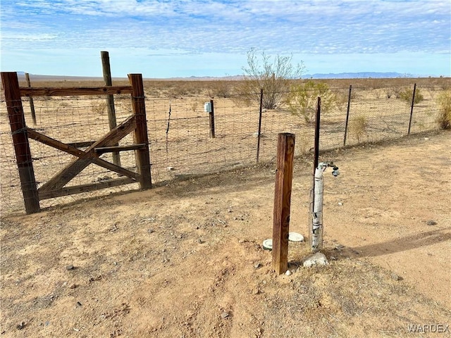 view of yard with a gate, a rural view, and fence