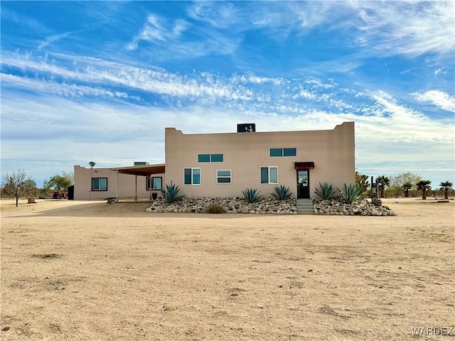 rear view of property featuring stucco siding