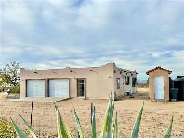 exterior space with an attached garage and stucco siding