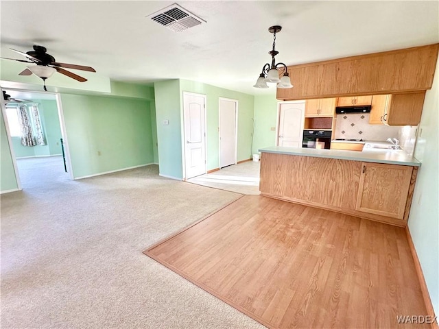 kitchen with open floor plan, visible vents, light countertops, and decorative light fixtures