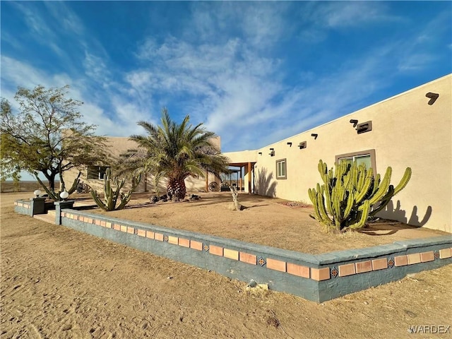 rear view of property featuring stucco siding