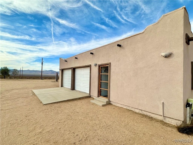 rear view of house featuring a mountain view and stucco siding