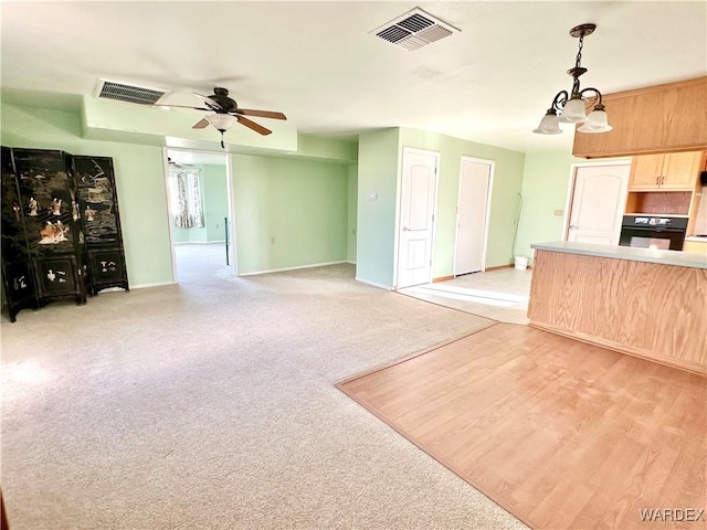 kitchen featuring light countertops, visible vents, hanging light fixtures, light brown cabinetry, and open floor plan