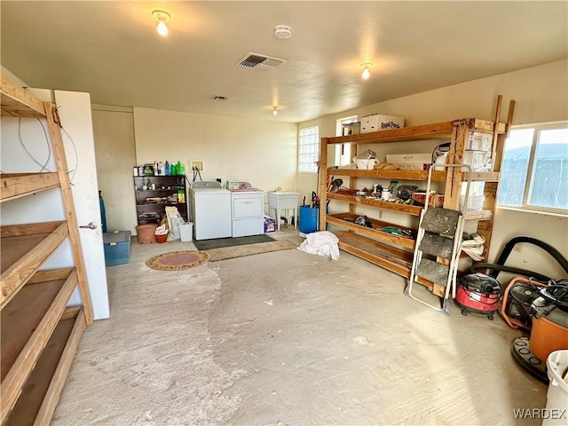 storage room with washing machine and clothes dryer and visible vents