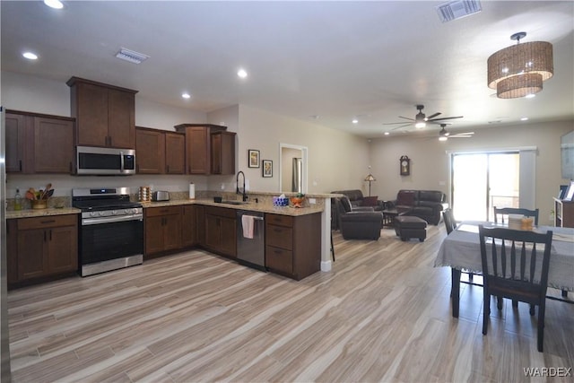 kitchen featuring open floor plan, appliances with stainless steel finishes, a sink, and visible vents