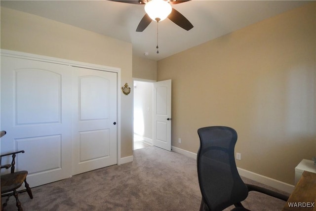 office featuring light colored carpet, ceiling fan, and baseboards