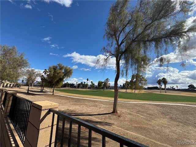 view of property's community with a yard, golf course view, and fence