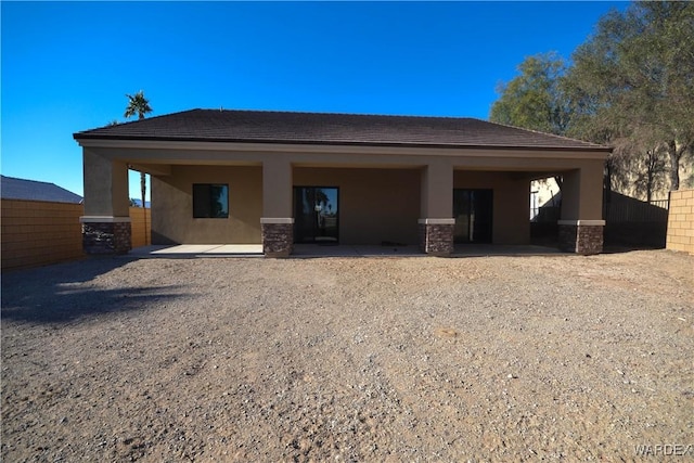 back of property featuring stone siding and stucco siding