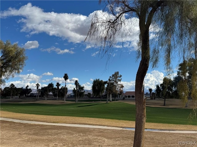 view of community featuring golf course view and a yard