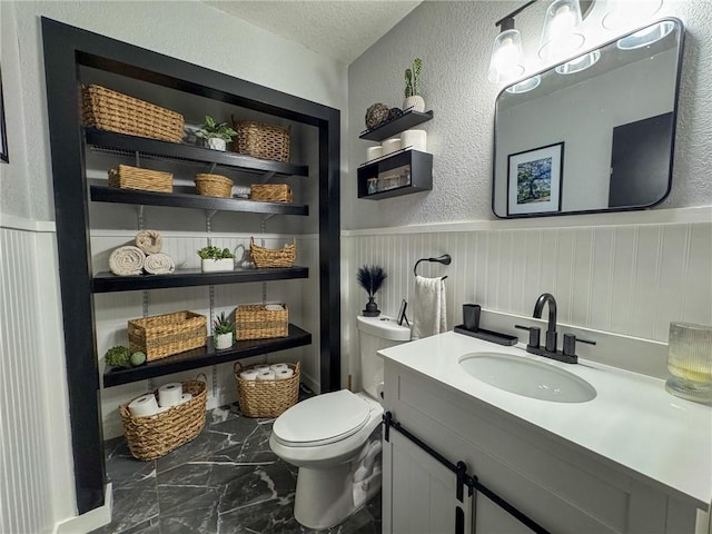 1189 Juanita Ln, Bullhead City, AZ 86442 - bathroom with a wainscoted wall, a textured wall, vanity, and a textured ceiling