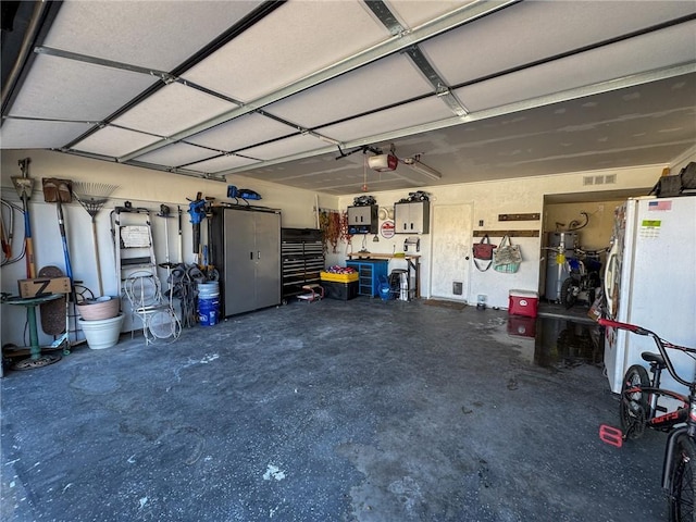 1189 Juanita Ln, Bullhead City, AZ 86442 - garage with a garage door opener, freestanding refrigerator, and secured water heater