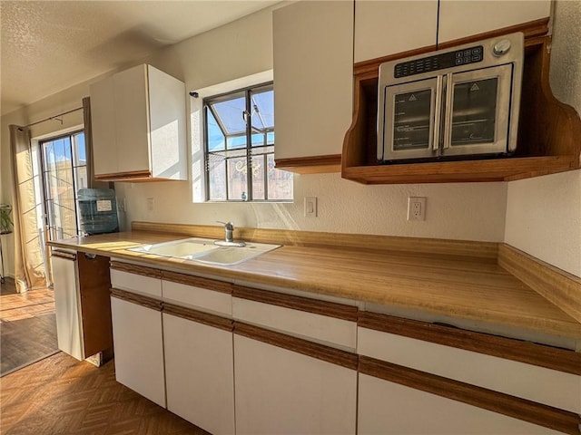 1189 Juanita Ln, Bullhead City, AZ 86442 - kitchen featuring white cabinets, plenty of natural light, and light countertops