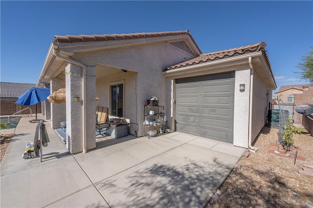 view of front of home with a tile roof, stucco siding, fence, an attached garage, and central AC unit