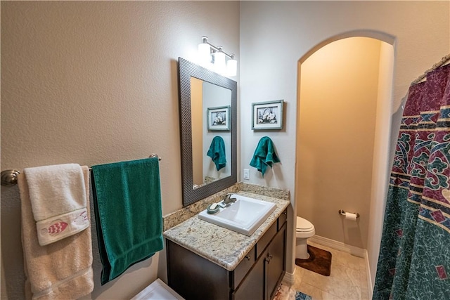 full bathroom featuring toilet, vanity, and tile patterned floors