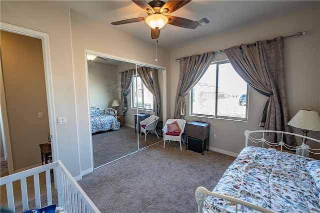 carpeted bedroom with a closet, baseboards, and a ceiling fan