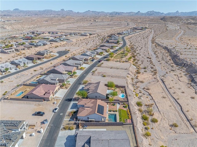 aerial view of residential area featuring mountains and a desert landscape