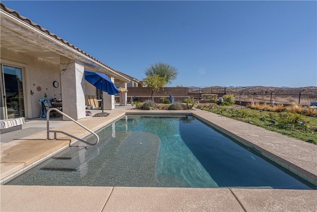 view of swimming pool featuring a patio and fence