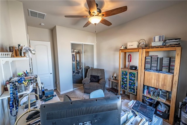 carpeted living area with ceiling fan and baseboards