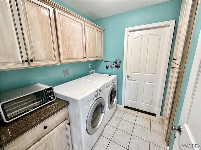 washroom featuring cabinet space, light tile patterned floors, and separate washer and dryer