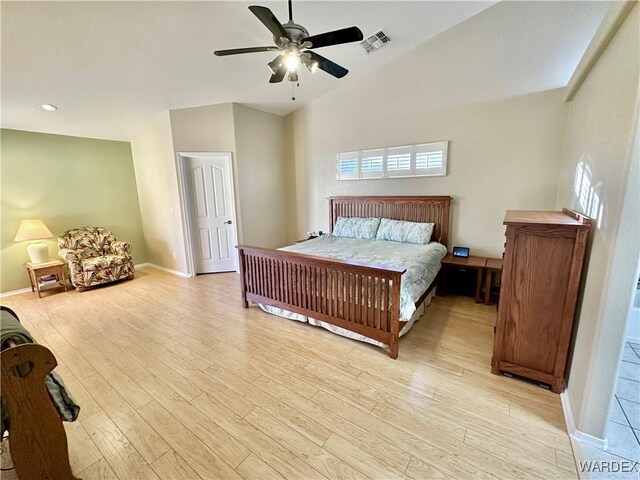 bedroom with light wood finished floors, baseboards, visible vents, arched walkways, and high vaulted ceiling