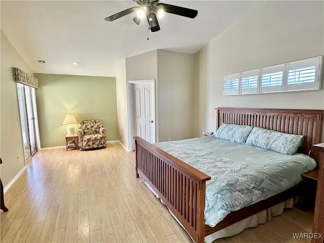 bedroom with vaulted ceiling, multiple windows, light wood-type flooring, and baseboards