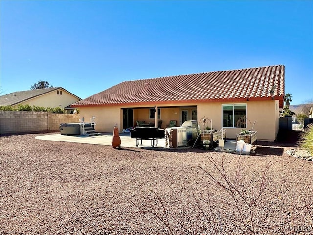 back of property featuring an outdoor living space, a patio, a hot tub, and stucco siding