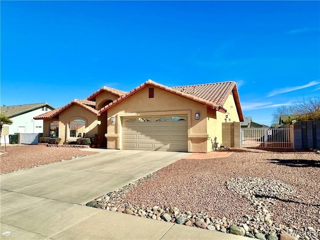 view of front of property with driveway, a garage, a tile roof, fence, and stucco siding