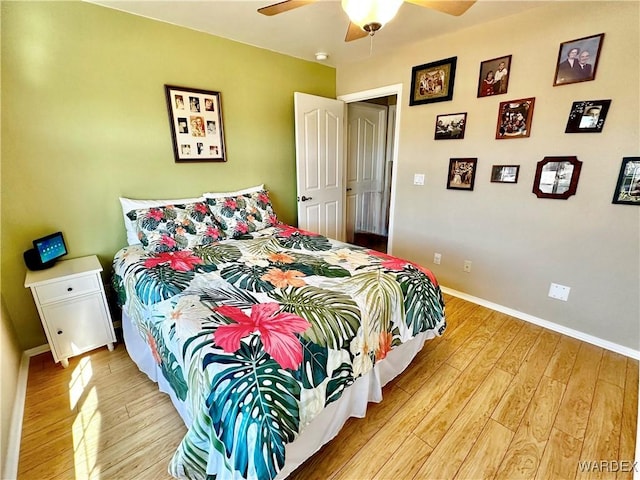 bedroom featuring light wood-type flooring, baseboards, and a ceiling fan