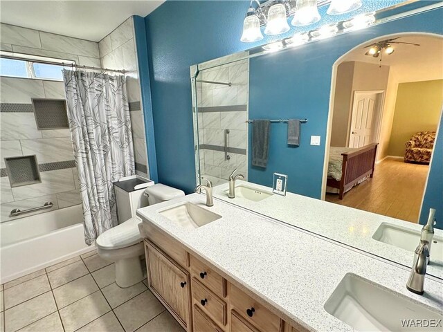 bathroom with shower / bath combination with curtain, a sink, and toilet