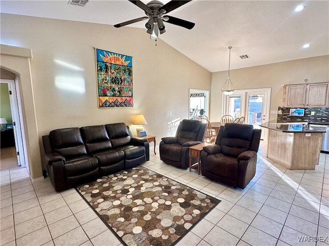 living area featuring light tile patterned floors, ceiling fan, arched walkways, and visible vents