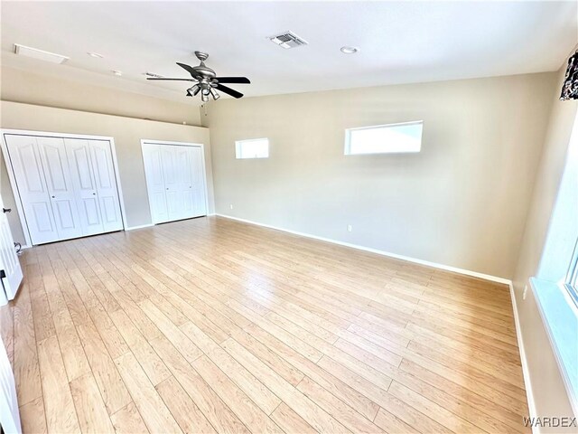 interior space featuring vaulted ceiling, ceiling fan, light wood-style flooring, and baseboards