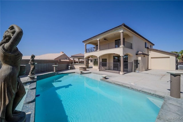 back of house with a fenced in pool, a patio, stucco siding, fence, and a balcony