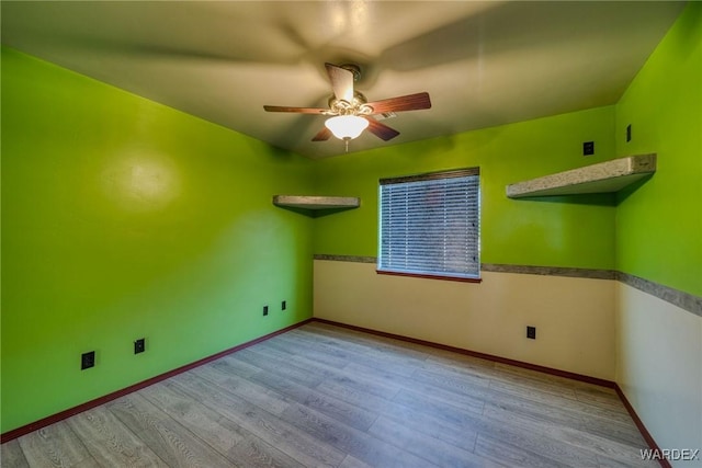 empty room featuring ceiling fan, light wood-style flooring, and baseboards