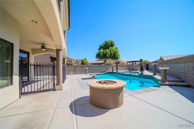 view of swimming pool featuring a patio area, a fenced backyard, ceiling fan, and a fire pit