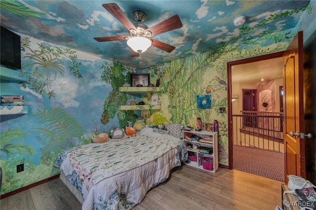 bedroom featuring baseboards, ceiling fan, wood finished floors, and wallpapered walls