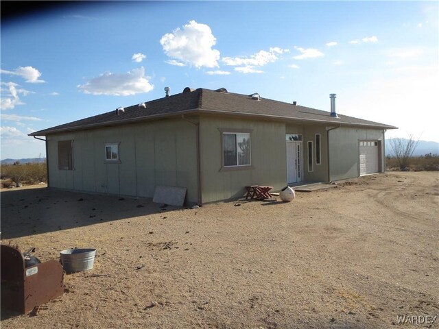 rear view of property with an attached garage