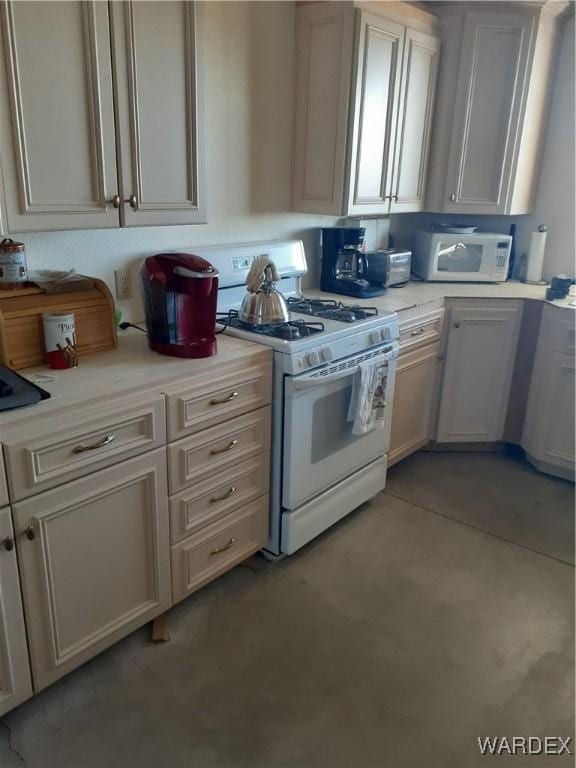 kitchen featuring white appliances, light countertops, and concrete floors