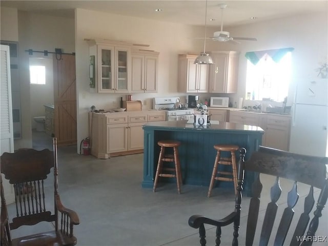 kitchen with a barn door, glass insert cabinets, ceiling fan, white appliances, and a kitchen bar