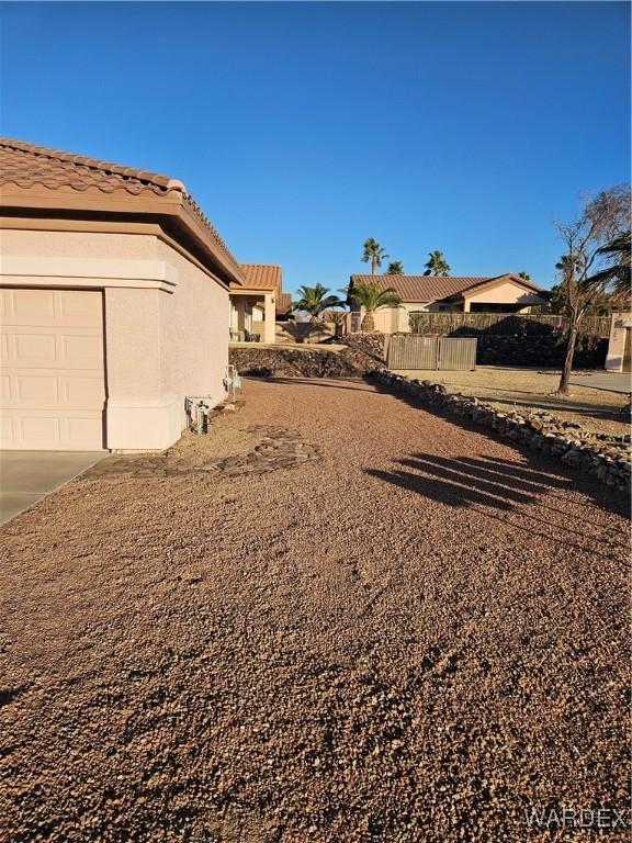 view of yard with an attached garage and fence