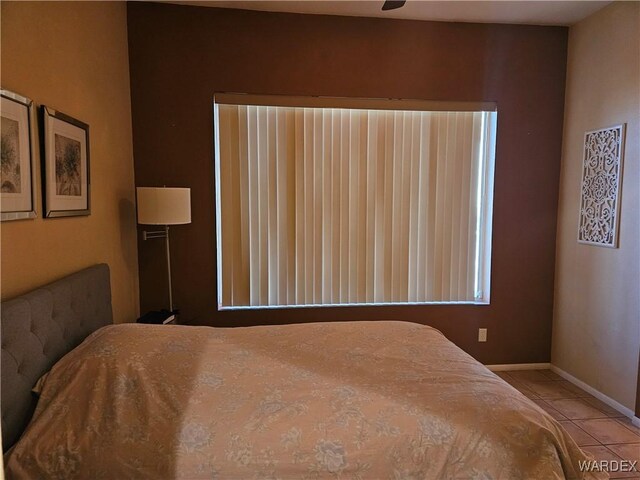 bedroom with baseboards and light tile patterned floors