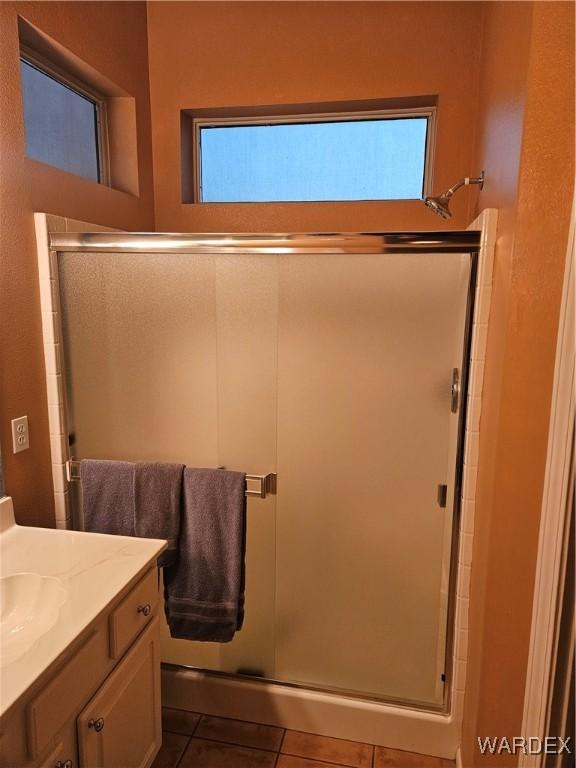 bathroom with a shower stall, vanity, and tile patterned floors