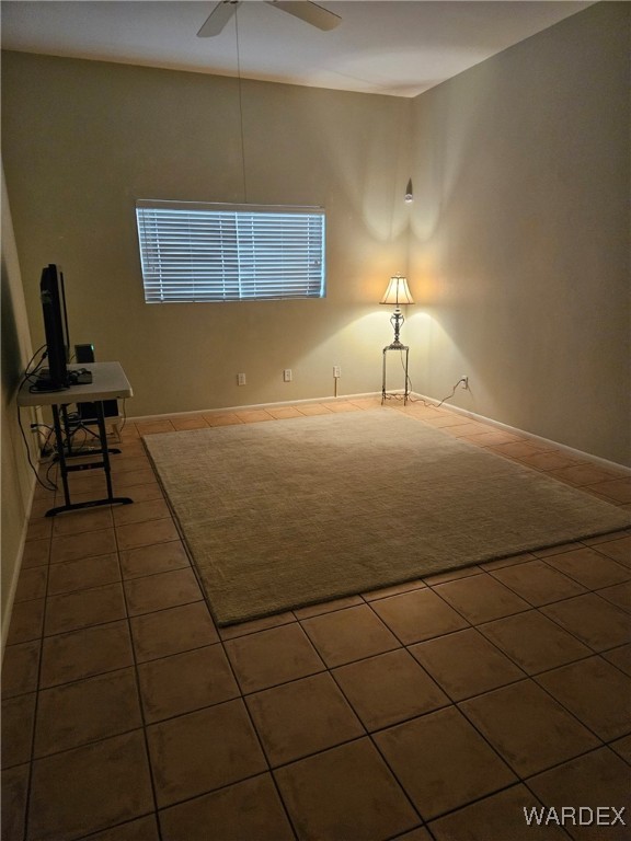 unfurnished living room with a ceiling fan and dark tile patterned flooring