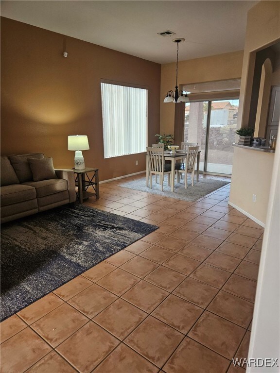 interior space with an inviting chandelier, baseboards, and visible vents